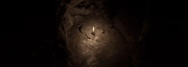 Une caverne obscure éclairée par la seule torche d'un joueur
