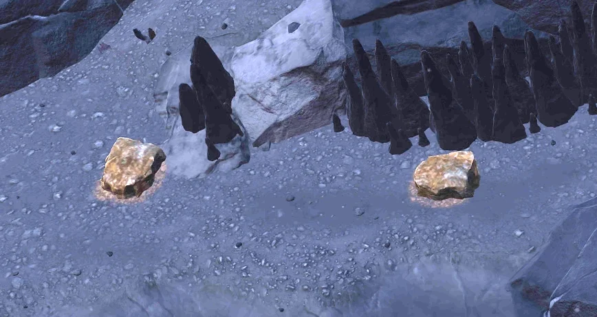 Deux petits tas de roche dorée sur le sol gris d’une salle, devant une rangée de stalagmites sombres